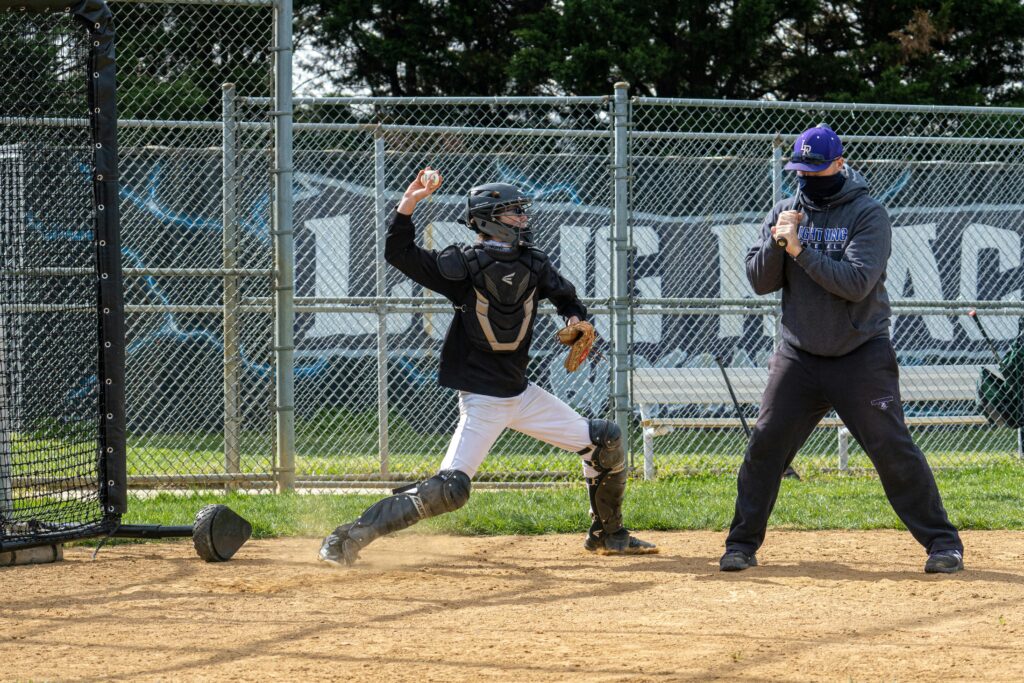 Catcher in baseball gear practicing on an outdoor field in Columbia, MD.